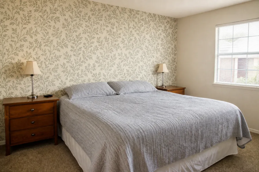 Same bedroom after sage trailing-leaf wallpaper installation